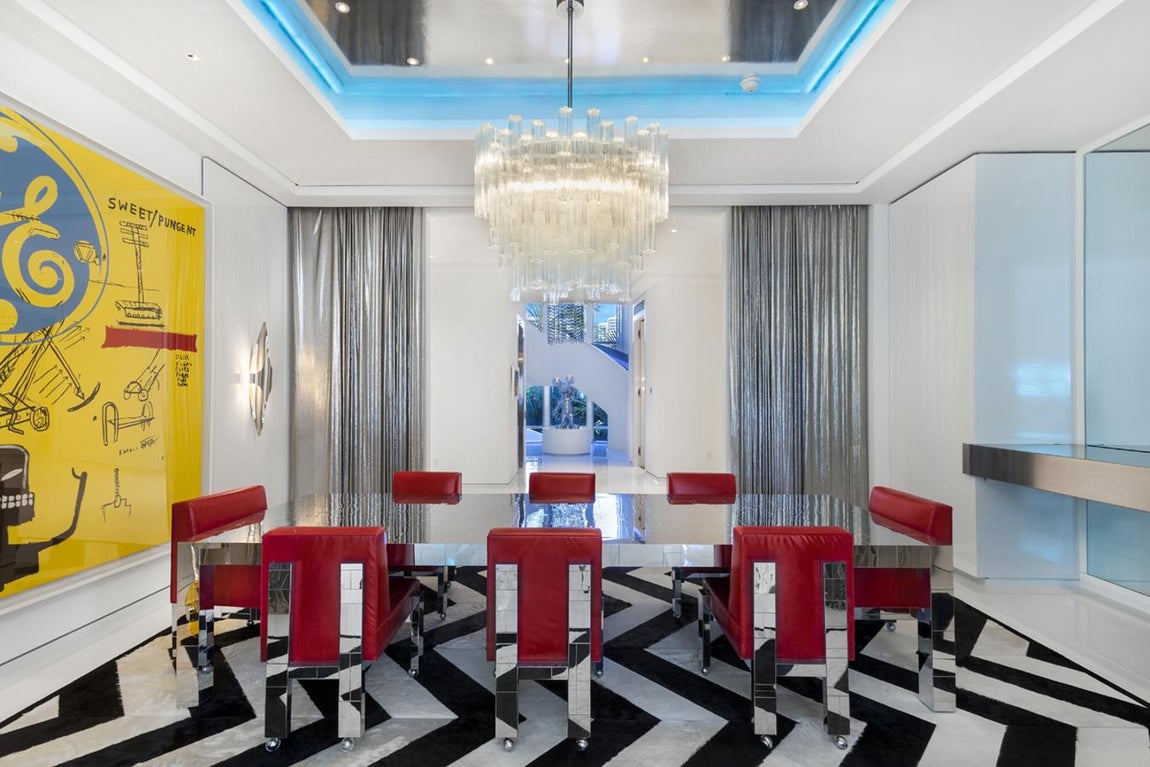 Comedor. La obra que da sentido al comedor es «Sweet Pungent», la pintaron cojuntamente Warholl y Basquiat. Entre la decoración, el protagonismo se lo llevan las cortinas de cota de malla. Las sillas vintage son de Paul Evans y la alfombra de Kyle Bunting