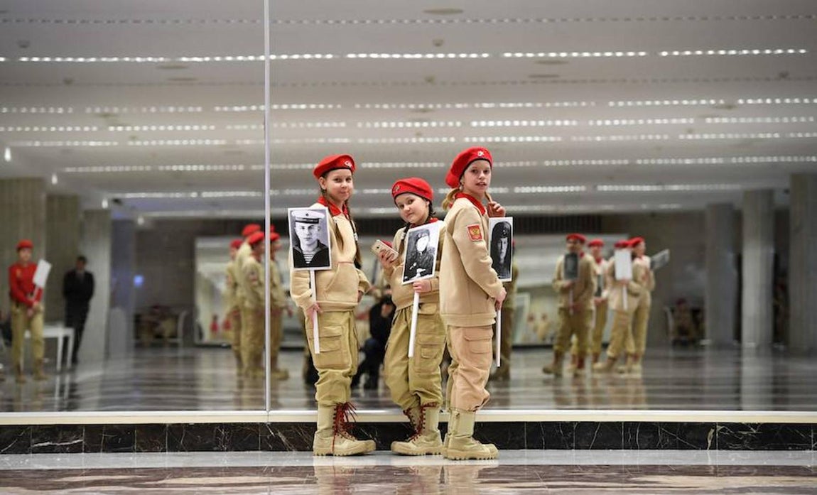 Rusia celebra la fiesta del Defensor de la Patria. Jóvenes militantes del movimiento ruso Yunarmiya (Joven Ejército), una organización patriótica , quienes posan junto a las fotografía sde héroes de la Segunda Guerra Mundial.