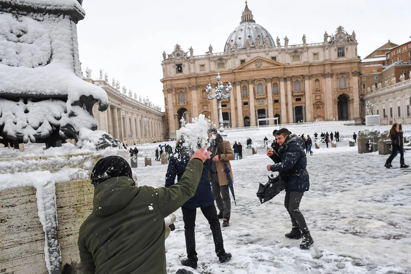 Turistas se lanzan bolas de nieve en la Plaza de San Pedro en el Vaticano. 