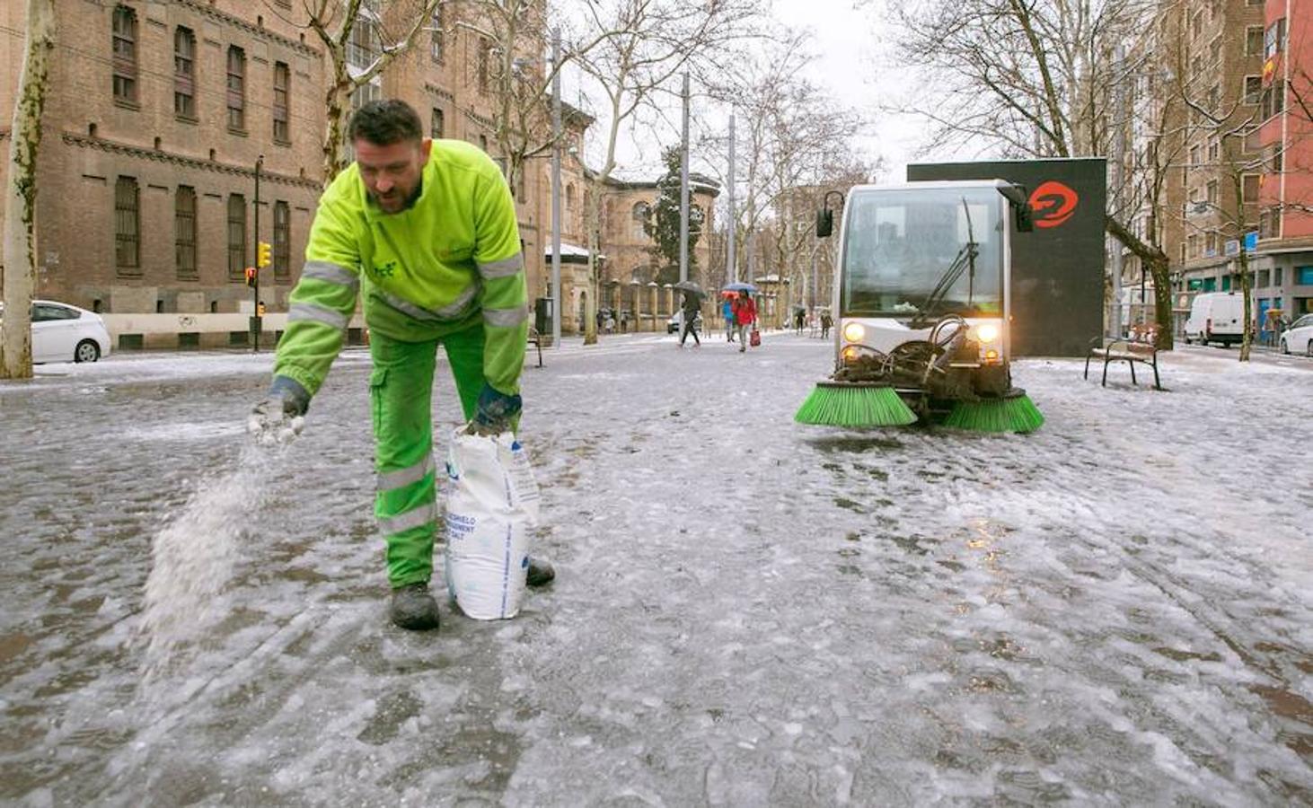 Esparcen sal en las calles nevadas y heladas de Zaragoza. 