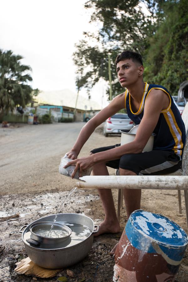 Jesús Ortiz lava los cacharros de su familia en un caño del que brota agua de un manantial. Precisamente, la falta de agua en las casas (se bombea con un sistema eléctrico) es lo que peor lleva este chico a punto de terminar el instituto en Utuado. «Es una enseñanza también, nos ha unido mucho a la familia», dice sobre los seis meses de penurias tras el huracán.. 