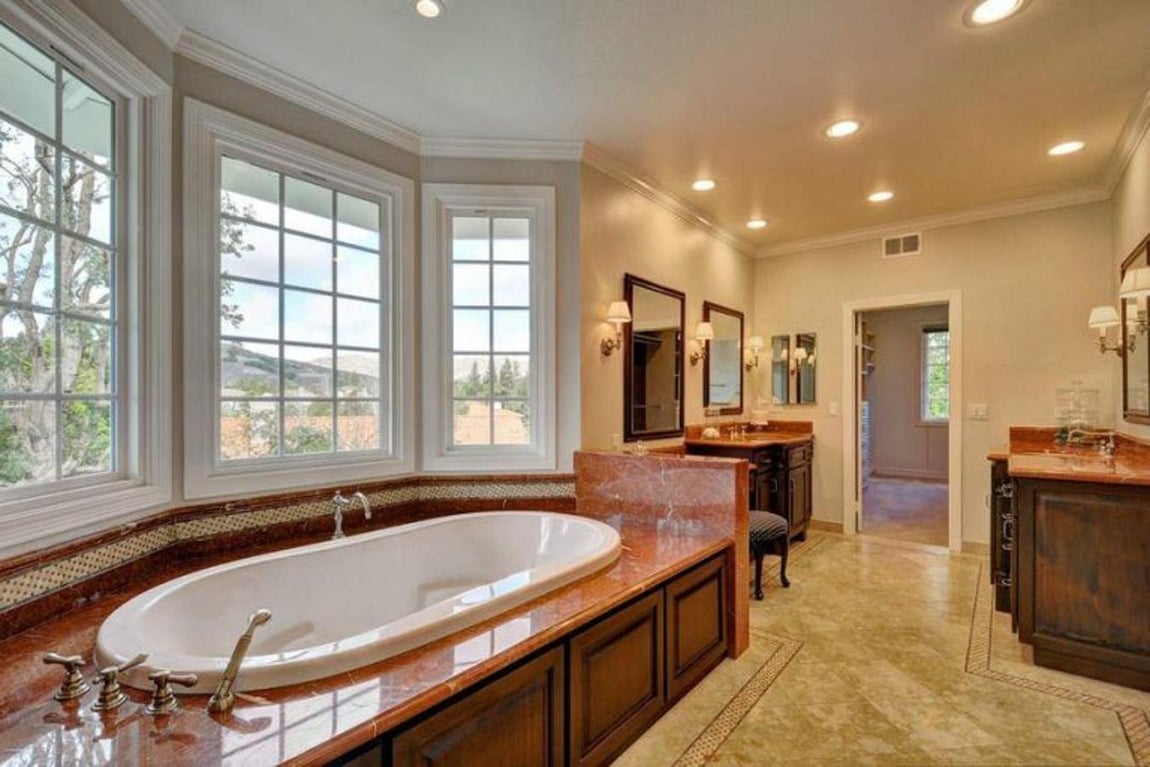 Cuarto de baño. Hecho en mármol y madera, de techos muy altos y abierto al exterior. Su enorme bañera es de lo más lujoso: grandes dimensiones y grifería clásica