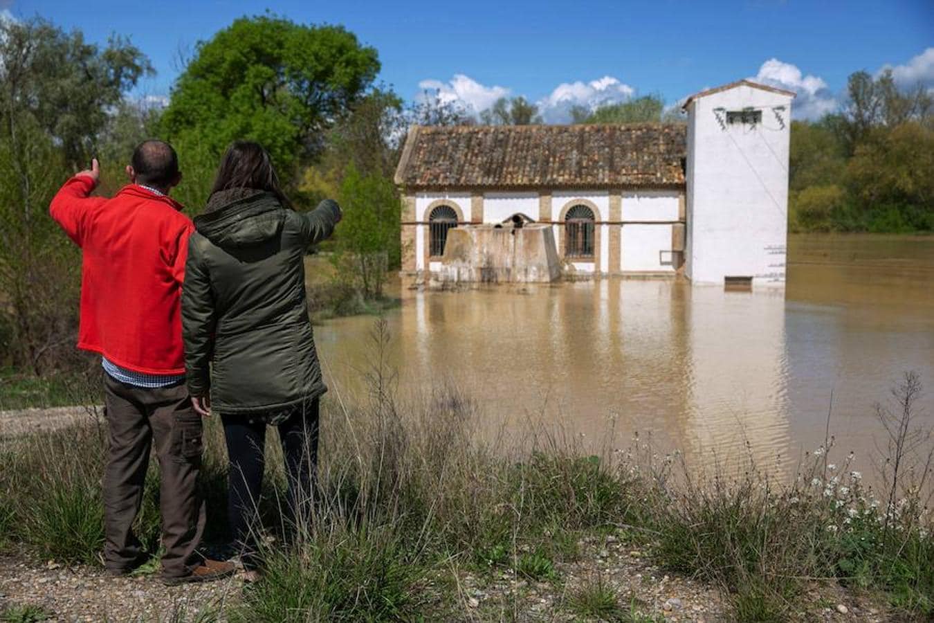 Unos vecinos contemplan una ermita inundada por el desbordamiento del rio Ebro en la localidad zaragozana de Boquiñeni. 