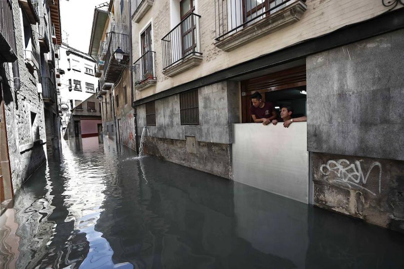 Dos personas observan como se encuentran las calles del casco viejo de Tudela, tras la inundación que ha sufrido el casco viejo de la ciudad por la crecida del rio Ebro. 