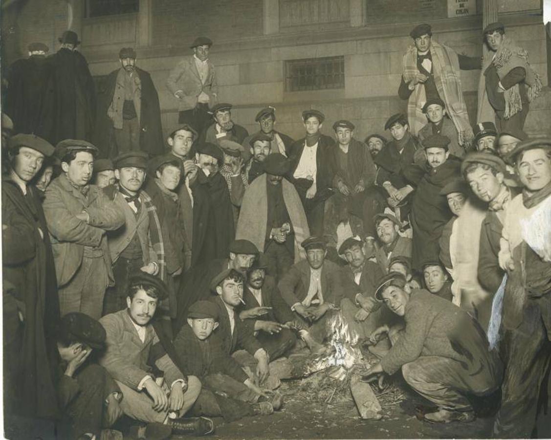 Un grupo de hombres se calienta alrededor de una hoguera delante de la Casa de la Moneda a las dos de la madrugada, esperando el comienzo del sorteo de la Lotería de Navidad (1905). 