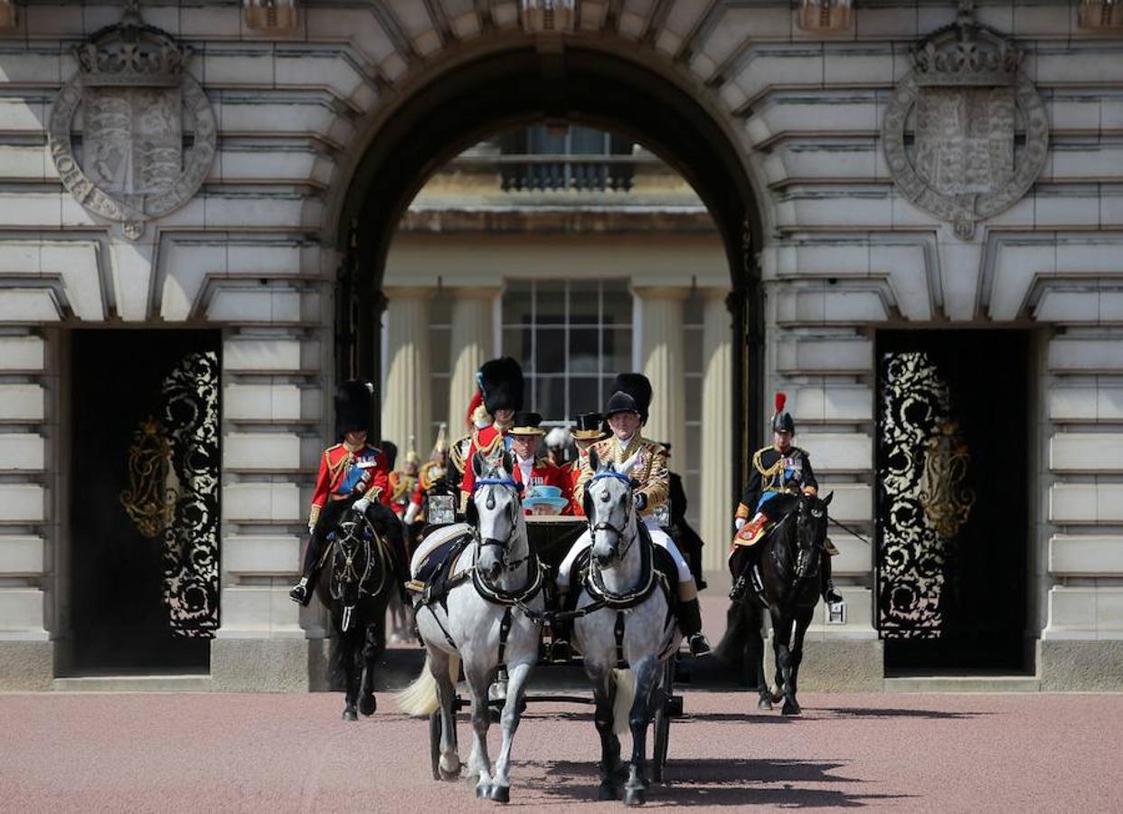 Palacio de Buckingham. La Reina Isabel II sale en su carruaje escoltada por caballos a ambos costados. Desfila en solitario, ya que su marido, el duque de Edimburgo, no la acompaña esta vez