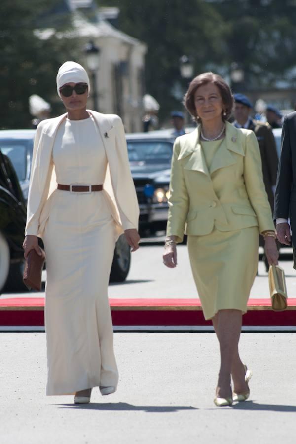 Con un elegante vestido blanco y americana, con la Reina Doña Sofía. 