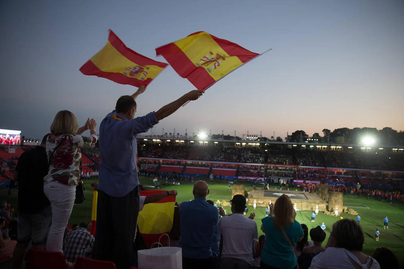 Dos personas agitan banderas al paso de los atletas españoles durante la inauguración de los XVIII Juegos Mediterráneos.. 
