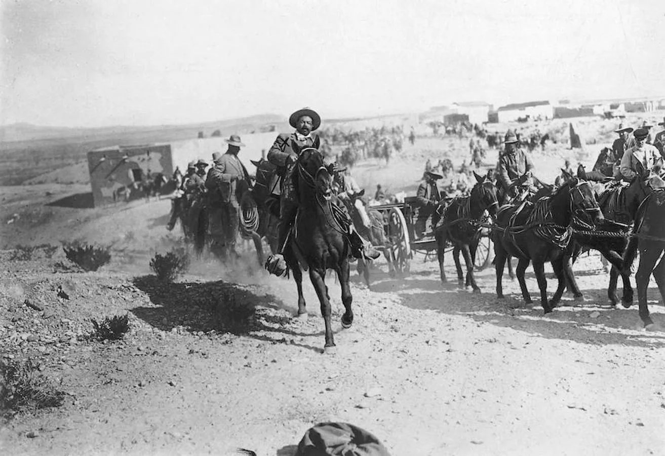 El general Pancho Villa a caballo seguido de sus soldados. 