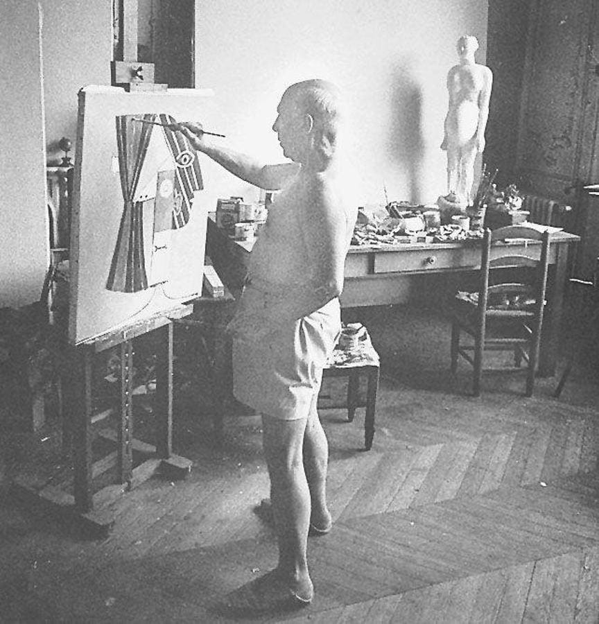 Pablo Picasso en su estudio pintando un cuadro. 