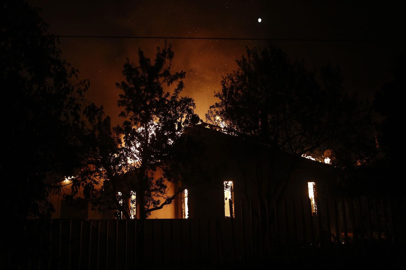 Una vivienda arde en llamas durante un incendio forestal en Mati, un suburbio al noreste de Atenas (Grecia). 