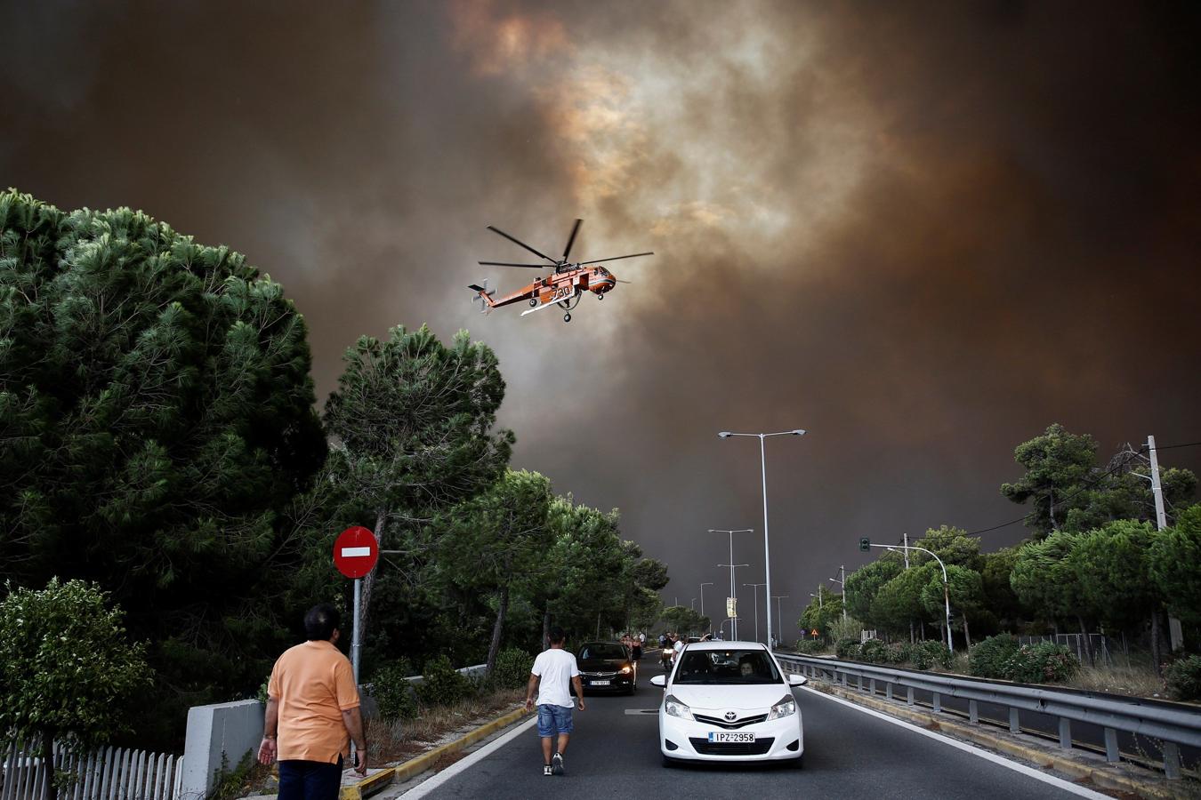 Bomberos tratan de extinguir un incendio en Penteli, al norte de Atenas (Grecia). 