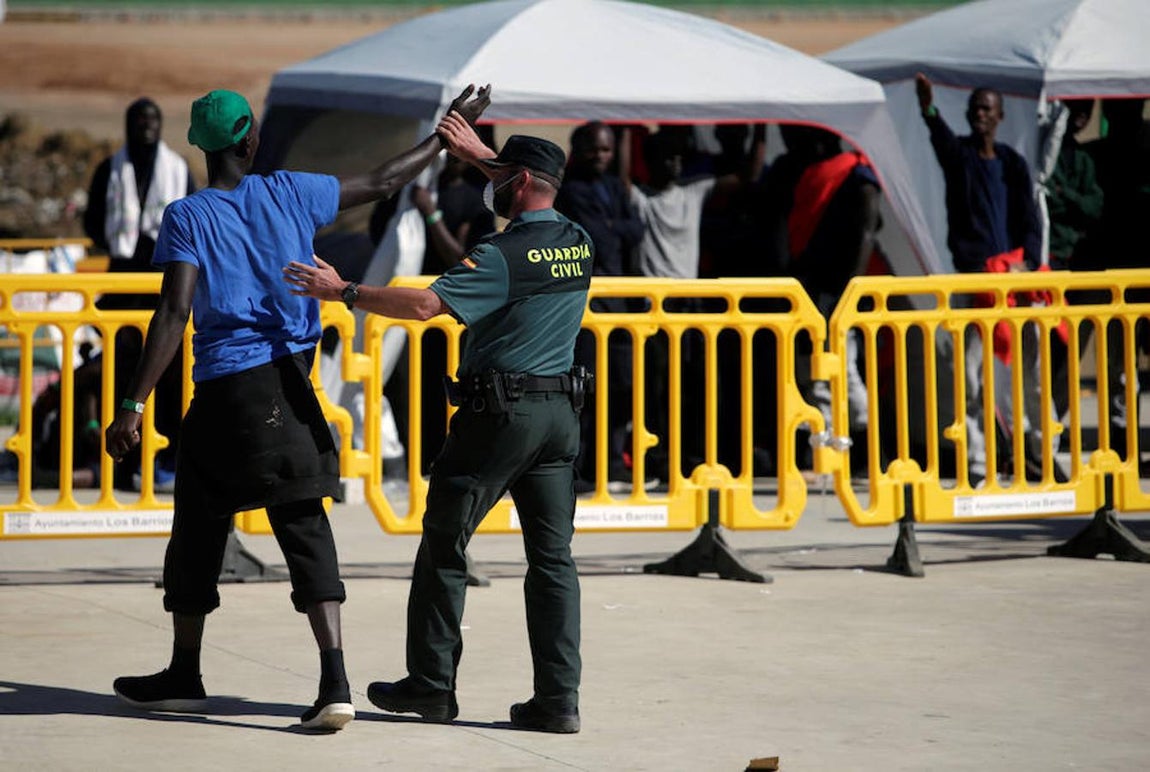 Uno de los guardias civiles –que cuida y vigila a las personas que llegan en patera a las costas de Cádiz y son trasladadas al pabellón «Antonio Gavira», en el municipio Los Barrios, cerca de Algeciras– aparta el brazo del inmigrante que se abrazaba a su cuello.. 