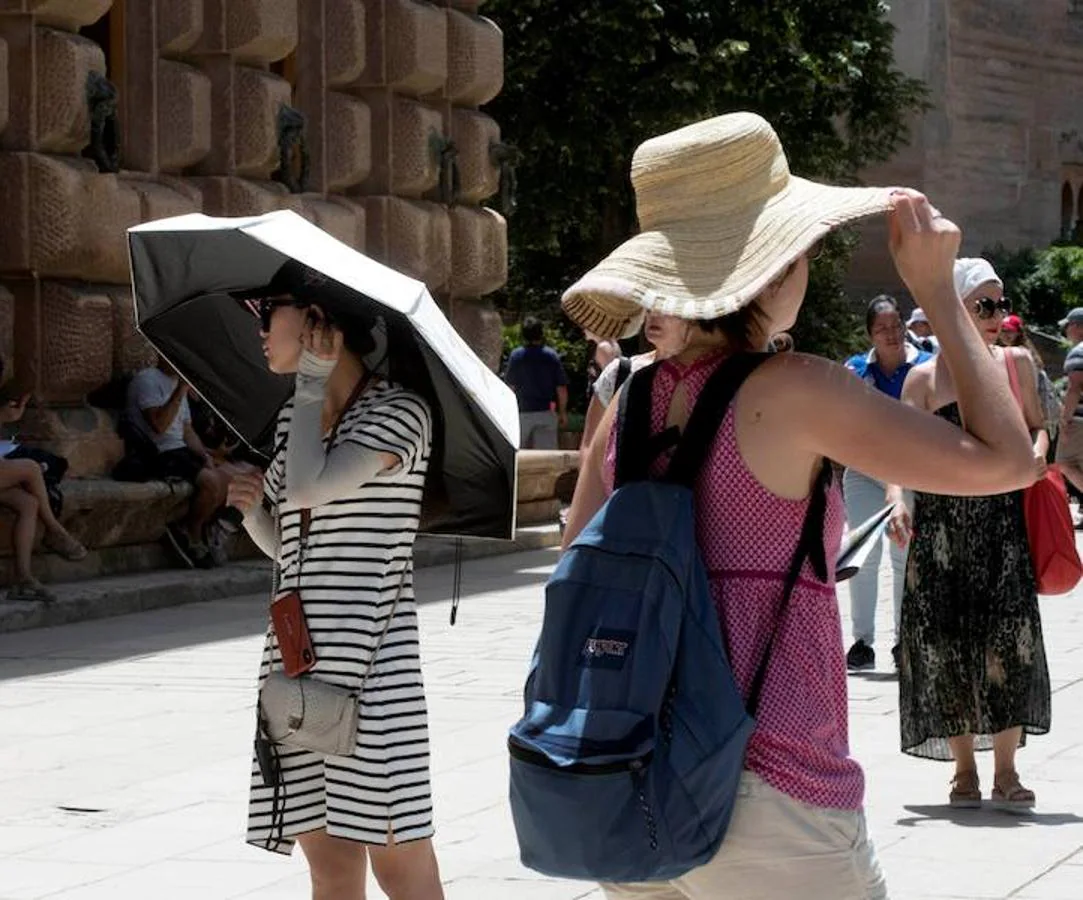 Los turistas de La Alhambra también sufren el calor. Turistas se protegen del sol en las inmediaciones de La Alhambra, Granada, por el intenso calor que en los próximos días dejarán temperaturas extremas en la Península y Baleares, con valores que llegarán hasta los 40 grados.