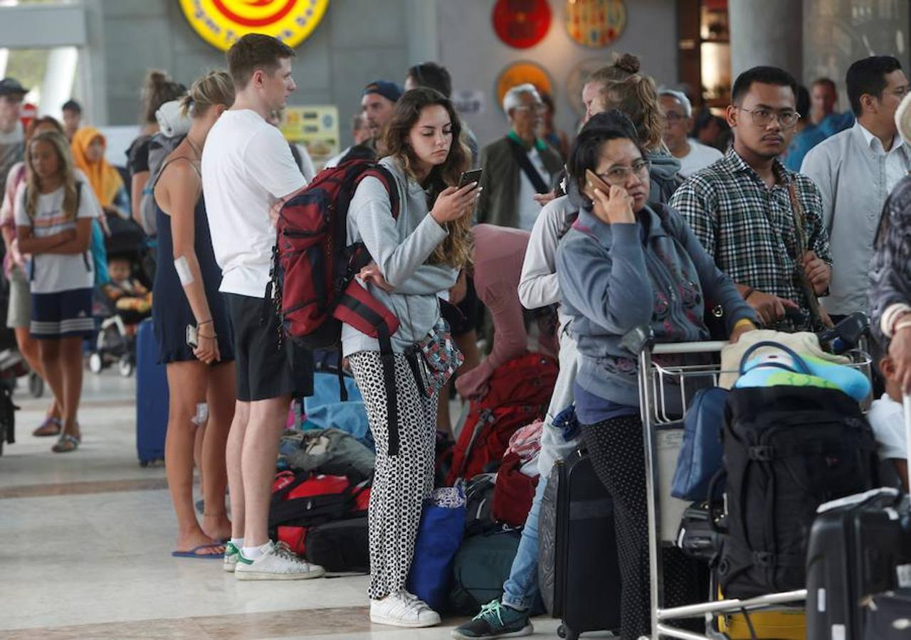 Los turistas tratan de abandonar el país. Turistas extranjeros esperan en los mostradores de facturación del aeropuerto Internacional Praya en Lombok, Indonesia.