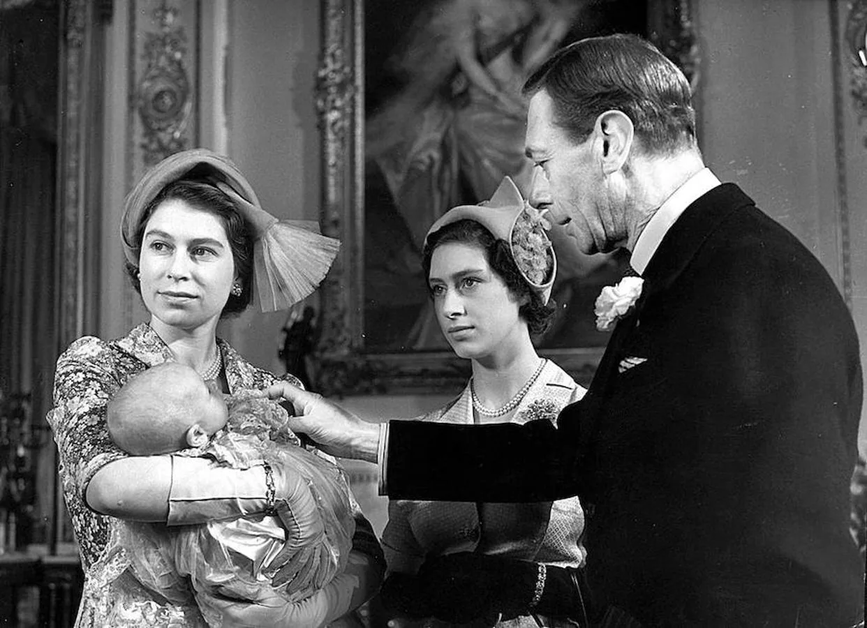 1950. Ana de Ingleterra, sobre los brazos de su madre, la futura Reina Isabel II, es acariciada por su abuelo, el Rey Jorge VI, en presencia de la Princesa Margarita