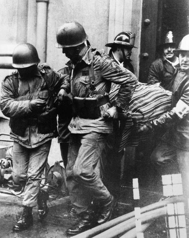 Varios soldados sacan el cuerpo sin vida del presidente Allende del Palacio Presidencial durante el asalto de este por parte de Pinochet. 