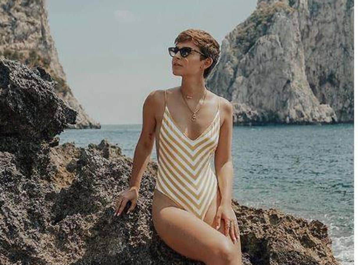 Laura Escanes, blanco y dorado. La modelo posa en las piedras de la playa con un bañador de «Stradivarius» que ha sido muy demandado. Lo combina con joyas también doradas , consiguiendo un «look» perfecto.