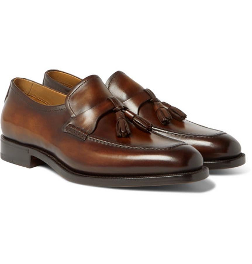 Mocasines de Berluti. La marca parisina se distingue por la máxima elegancia en cada uno de sus productos y estos mocasines marrones con borlas son un ejemplo más de ello. En este caso están adornados en Italia con la firma Venezia leather. Comodidad y distinción en el mismo par de zapatos. Precio: 1.580 euros.