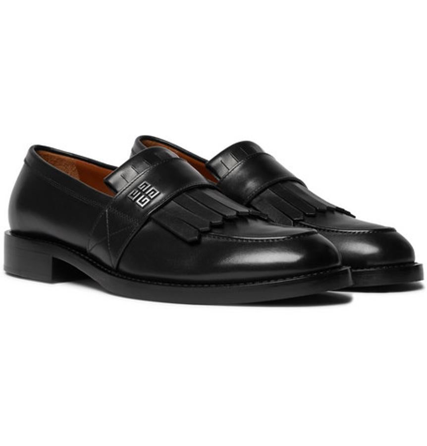 Mocasines de Givenchy. Los mocasines Cruz de Givenchy están cuidados hasta el mínimo detalle, que en este caso son las placas de plata grabadas con el monograma de la casa. Están elaborados en cuero negro y acabados con flecos, y sus suelas son de goma, muy resistente para soportar muchas horas de exposición. Precio: 695 euros.