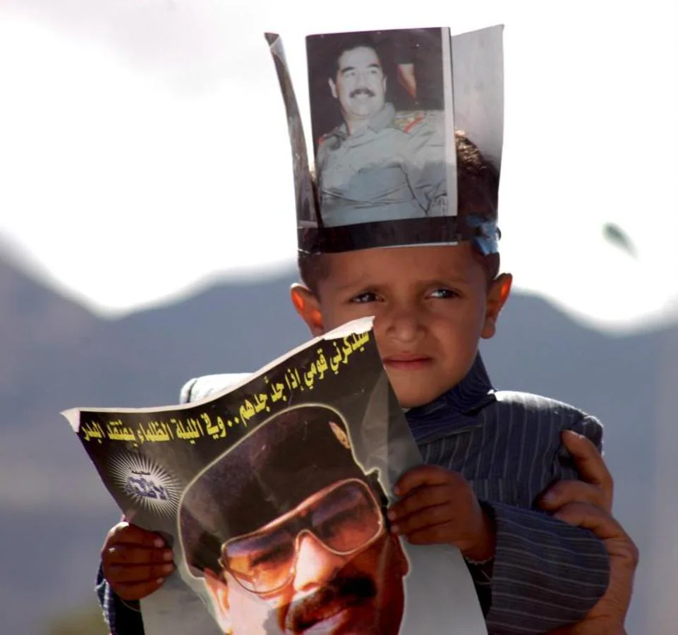 Un niño sostiene carteles con la imagen de Sadam Hussein en unas protestas en Yemen. 
