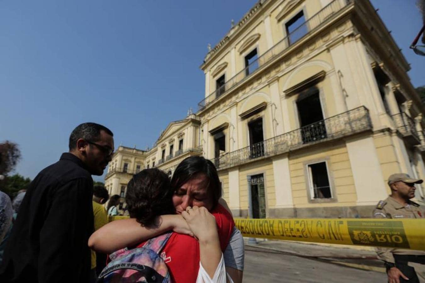 Dos funcionarias lloran ante la fachada del Museo Nacional