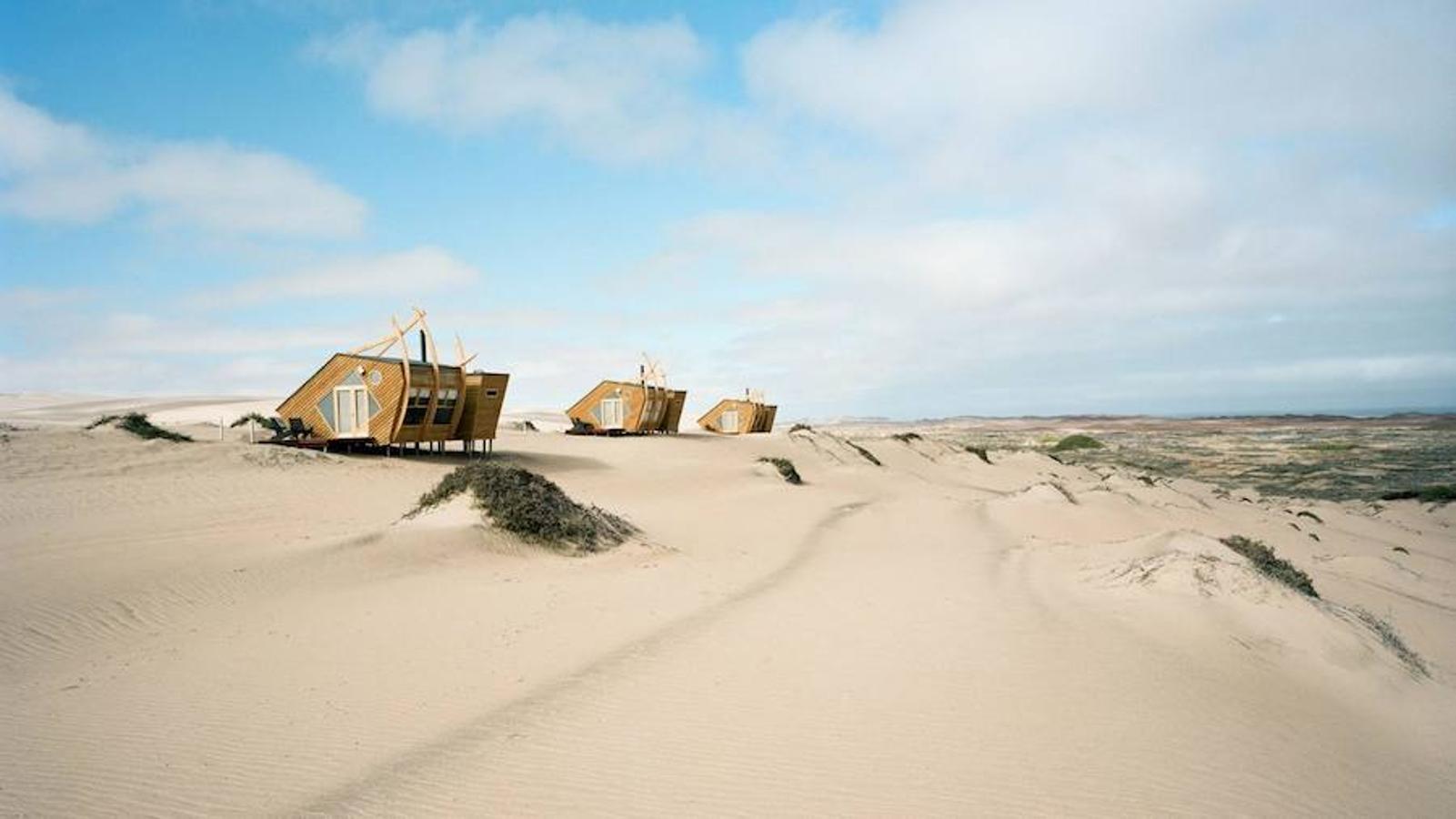 Cabañas de madera de Shipwreck Lodge. Las cabañas evocan los barcos varados entre el desierto y el océano de Namibia