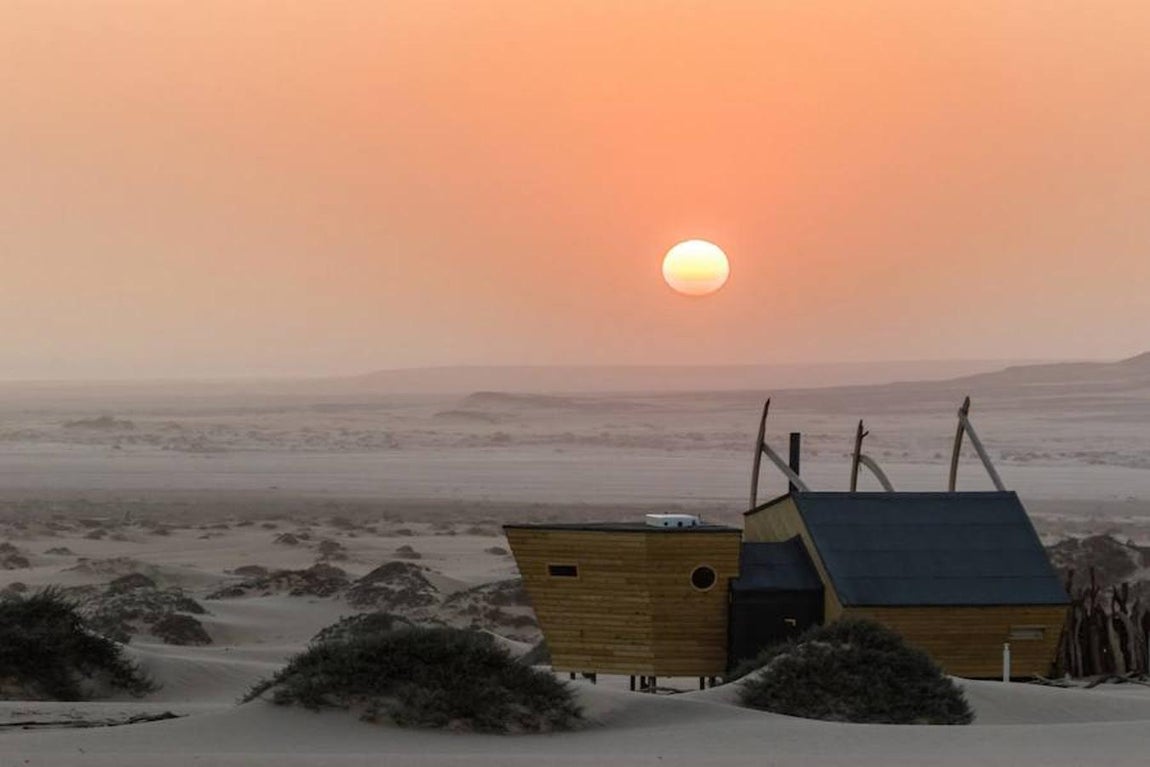 Cabañas de madera de Shipwreck Lodge. Las cabañas evocan los barcos varados entre el desierto y el océano de Namibia