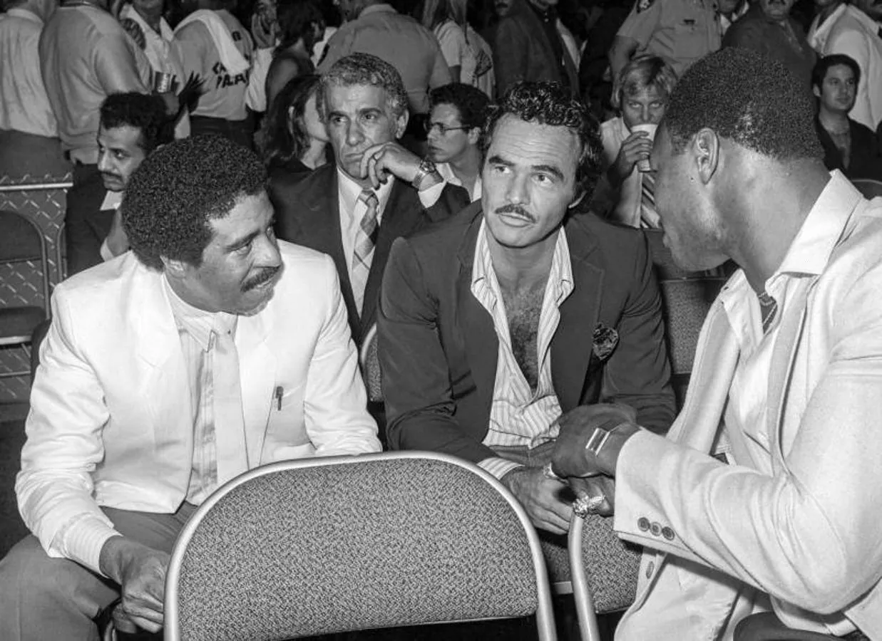 Vida pública. Burt Reynolds (centro) hablando con comediante Richard Pryor (izquierda) en la pelea de boxeo por el título mundial de peso mediano entre Sugar Ray Leonard y Thomas Hearns durante 1981.