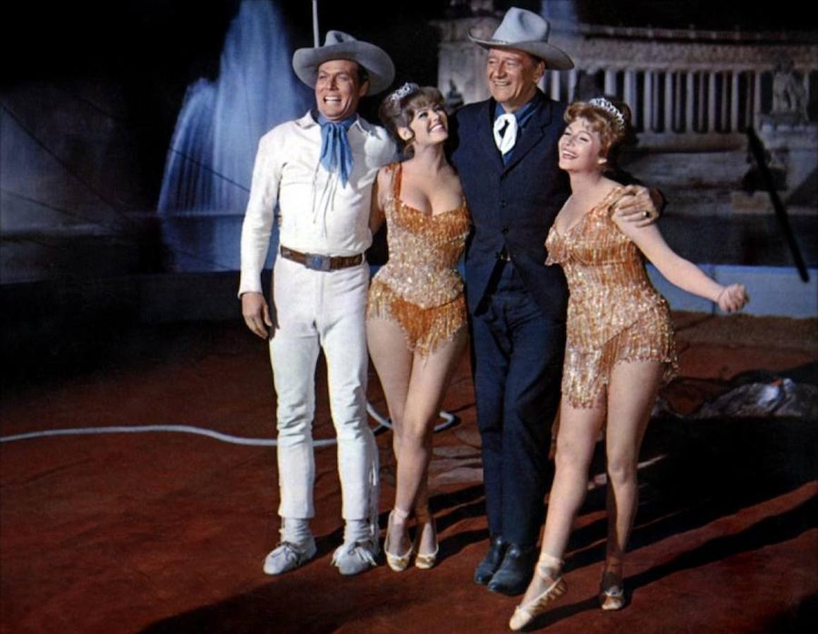 24.. De izquierda a derecha: John Smith, Claudia Cardinale, John Wayne y Rita Hayworth, con el estanque de El Retiro al fondo, que se vació para rodar la película «El maravilloso mundo del circo» en 1963