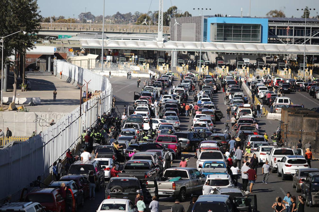 Cientos de inmigrantes tratan de cruzar por la fuerza la frontera entre México y EE.UU. en Tijuana. Los miembros de la caravana rompen el cerco policial y corren para intentar pasar a Estados Unidos