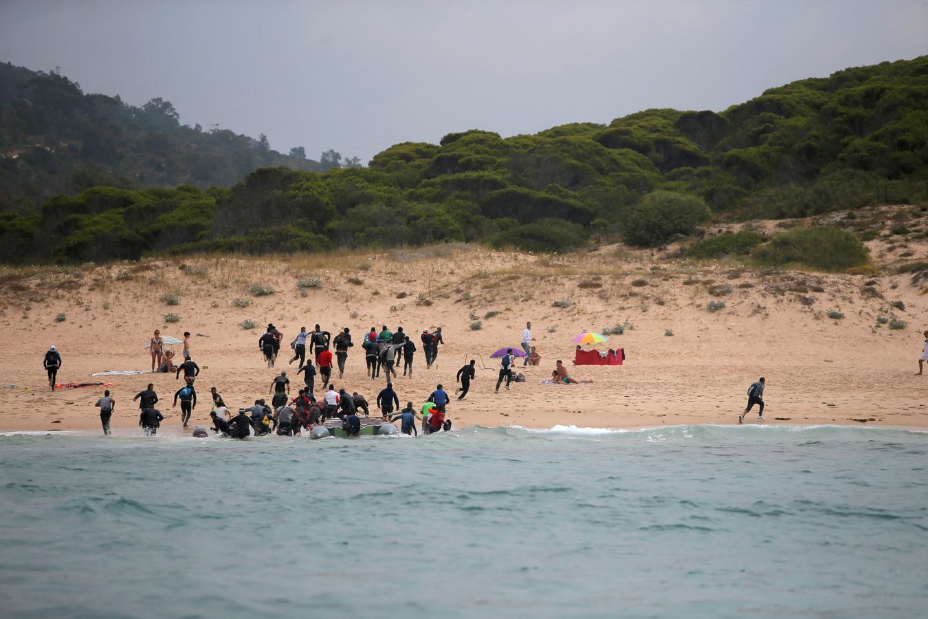 Los migrantes desembarcan de un bote en la playa del Canuelo después de cruzar el Estrecho de Gibraltar navegando desde la costa de Marruecos, en Tarifa, sur de España, el 27 de julio de 2018.. 