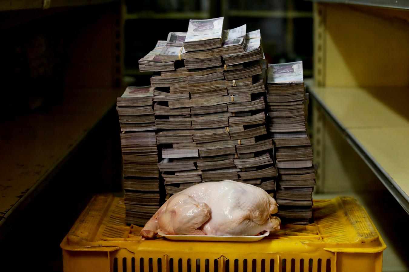 Imagen de un pollo de 2.4 kilogramos junto a 14,600,000 bolívares, su precio y el equivalente a 2.22 USD, en un minimercado en Caracas, Venezuela, el 16 de agosto de 2018.. 