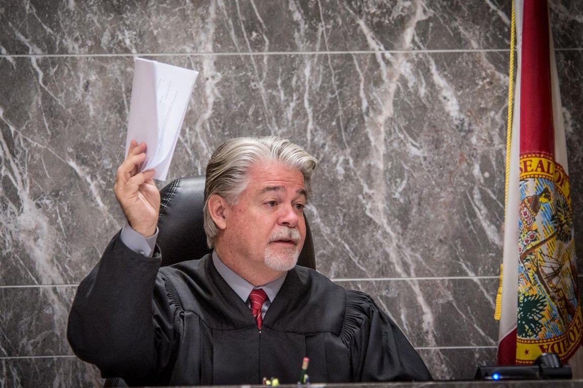 El juez Dennis Bailey muestra el auto que determina la culpabilidad de Ibar. 