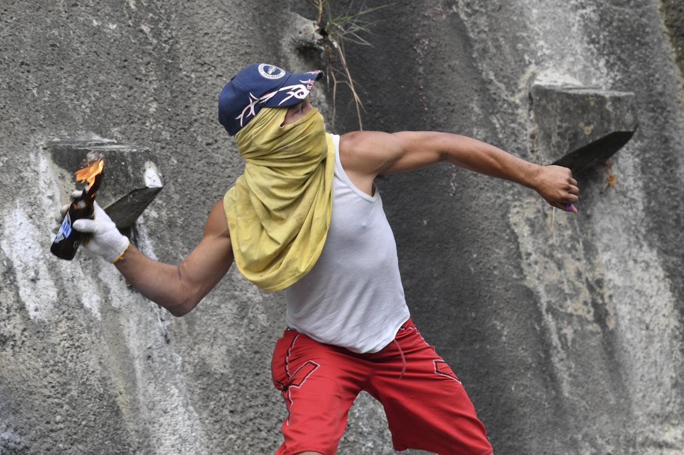 Las imágenes más dramáticas de la sublevación militar en Venezuela. Un manifestante arroja una bomba Molotov a la Policía