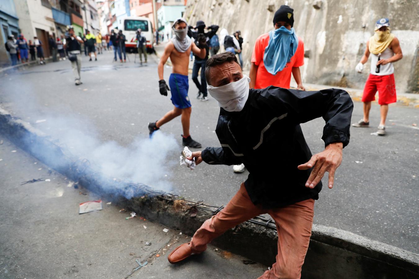Las imágenes más dramáticas de la sublevación militar en Venezuela. Un chico lanza una piedra a los efectivos de la Policía