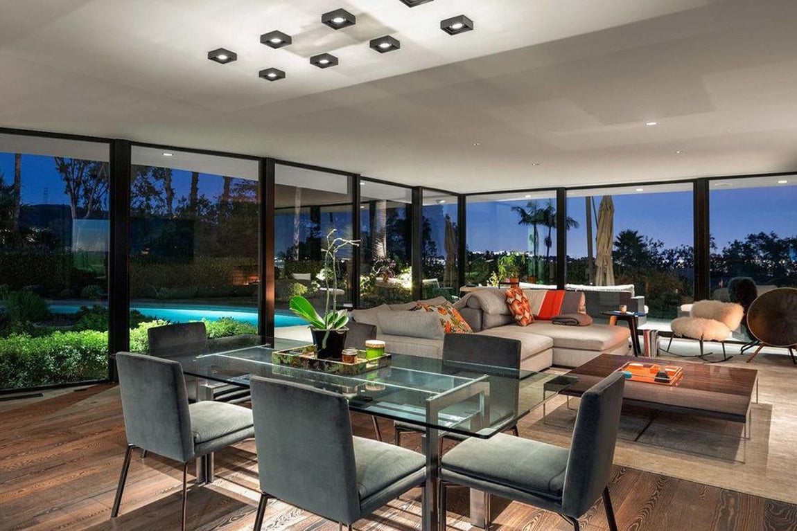 Salón. La casa, que se ubica en un terreno triangular, se completa con cuatro habitaciones y otros cuatro baños, cocina gourmet y toda la vivienda tiene grandes ventanales que permiten una magnífica iluminación natural. Además, los espacios son abiertos y muy grandes, de forma que todo queda unido: la cocina con el comedor y este a su vez con un inmenso salón.