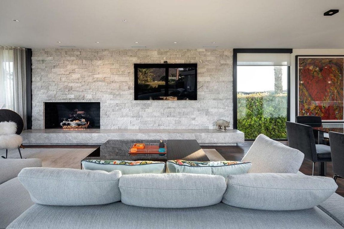 Salón. La sala de estar, donde se encuentra el comedor y el salón, es la estancia principal de la vivienda. En la mesa junto a la cocina caben cuatro comensales y después hay otra mesa para seis. Se calcula que más de 16 personas pueden ocupar el lugar teniendo en cuenta los grandes sofás y los demás sillones que completan el espacio.