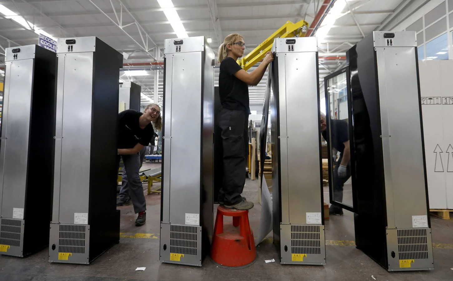 Dos trabajadoras en las fases finales de montaje de vitrinas refrigeradoras en la planta de Efficold
