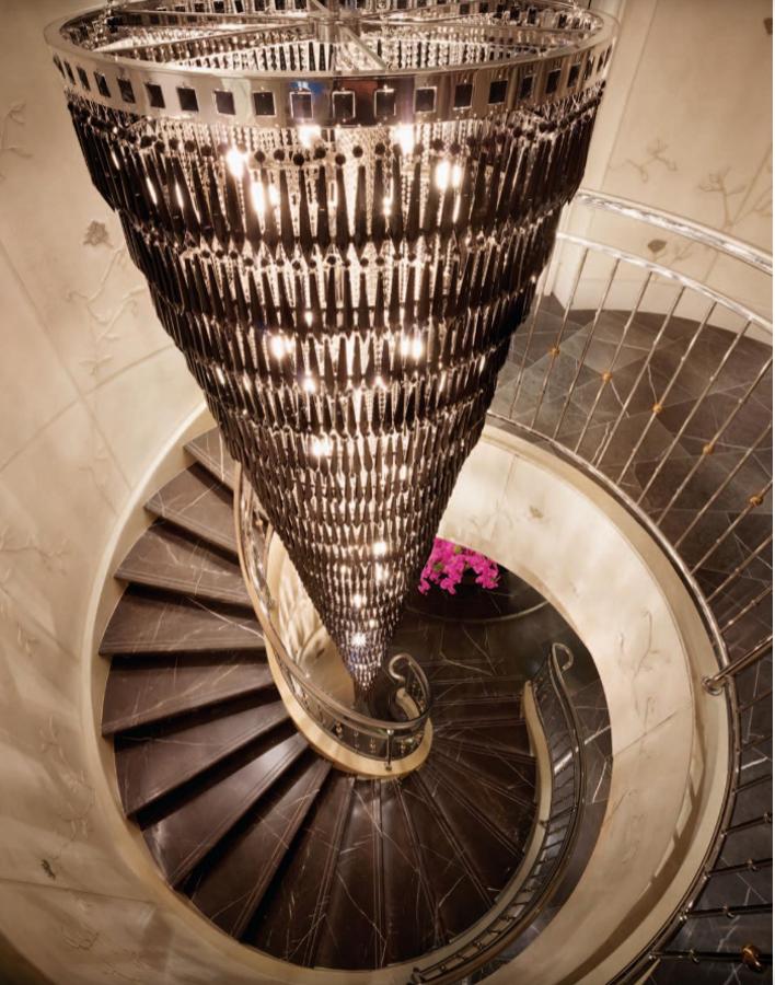 Escalera. Corona este punto de unión entre el espacio funcional y el espacio enfocado al descanso una valiosa lámpara de araña