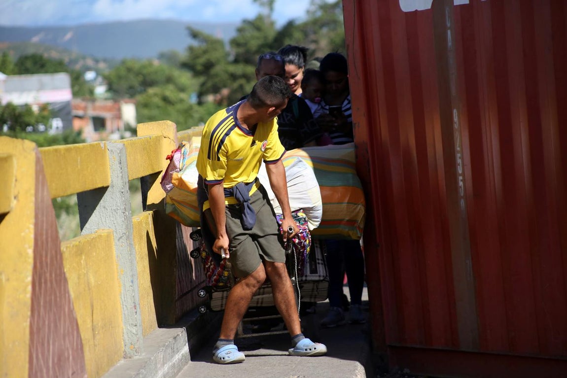 Un grupo de personas transporta sus pertenencias tras la apertura del paso. 
