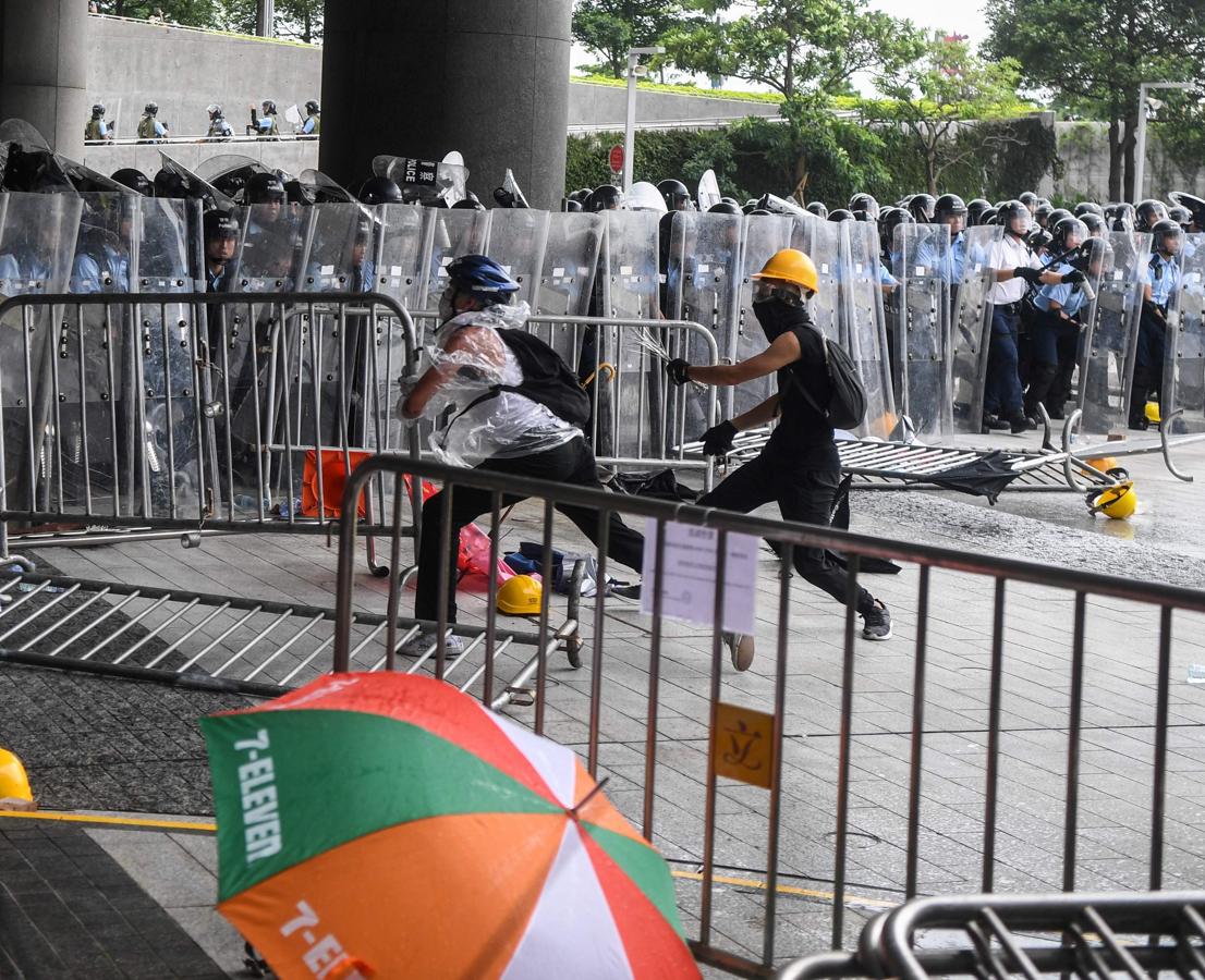 Dos manifestantes derriban las vallas de protección instaladas por las autoridades para proteger el Parlamento.. 