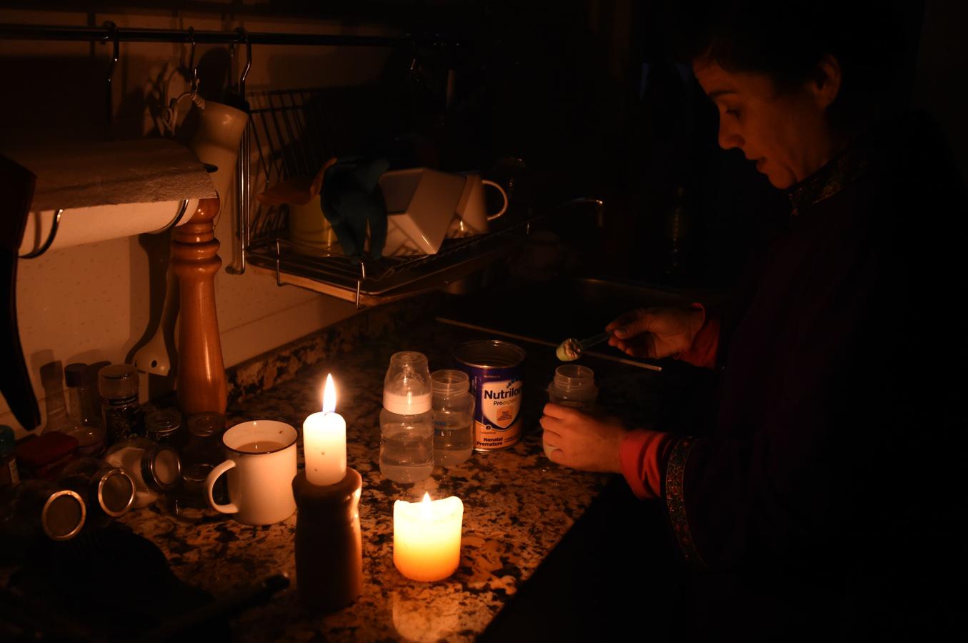 Una mujer prepara el biberón con velas en su casa en Montevideo. 