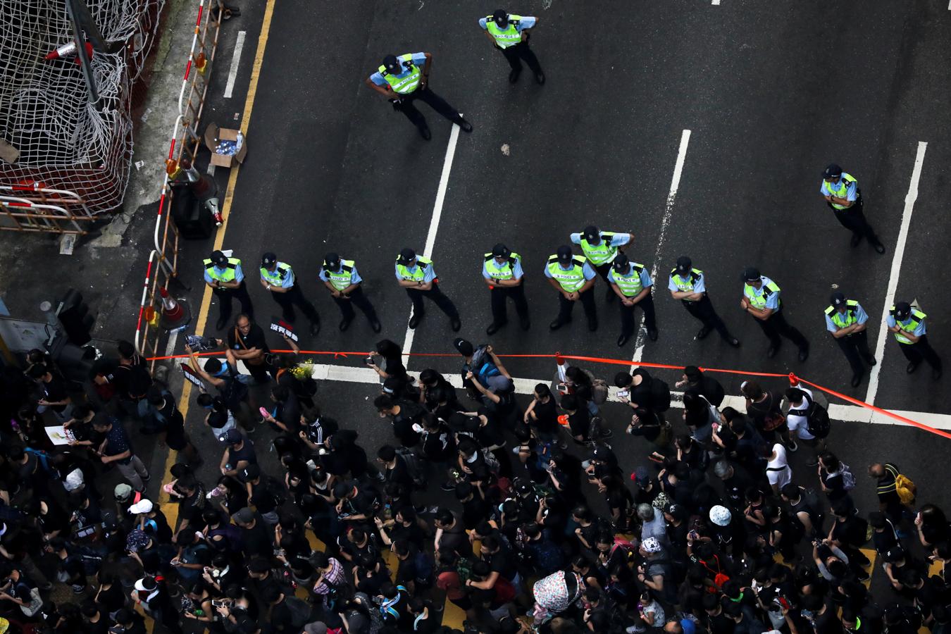 Cordón policial. La Policía de Hong Kong activa un cordón policial para frenar las protestas de los ciudadanos chinos que  exigen la retirada total de la ley de extradición a China (REUTERS)