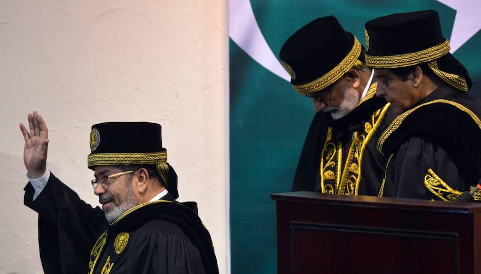 Mohamed Mursi (I) saluda cuando se va con el primer ministro pakistaní, Raja Pervez Ashraf (D), tras su discurso en la Universidad Nacional de Ciencia y Tecnología de Islamabad. 