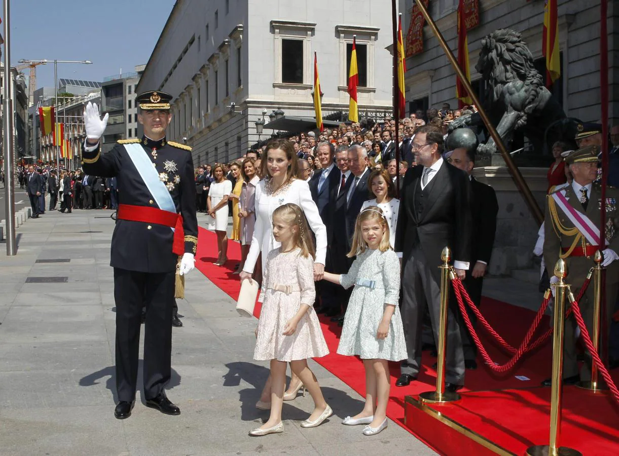 El Rey, junto a la Reina y sus hijas, la Princesa Leonor y la Infanta Sofía, saluda después del desfile que ha presidido a las puertas del Congreso tras su coronación. 
