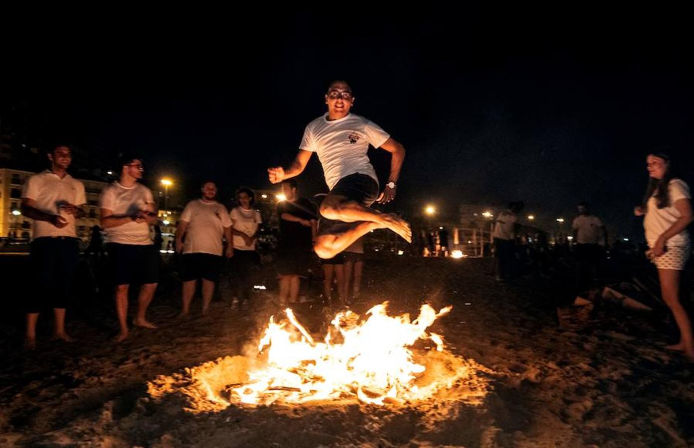 Un hombre salta sobre una hoguera durante las celebraciones anuales de San Juan en una playa de Alicante Valencia. 