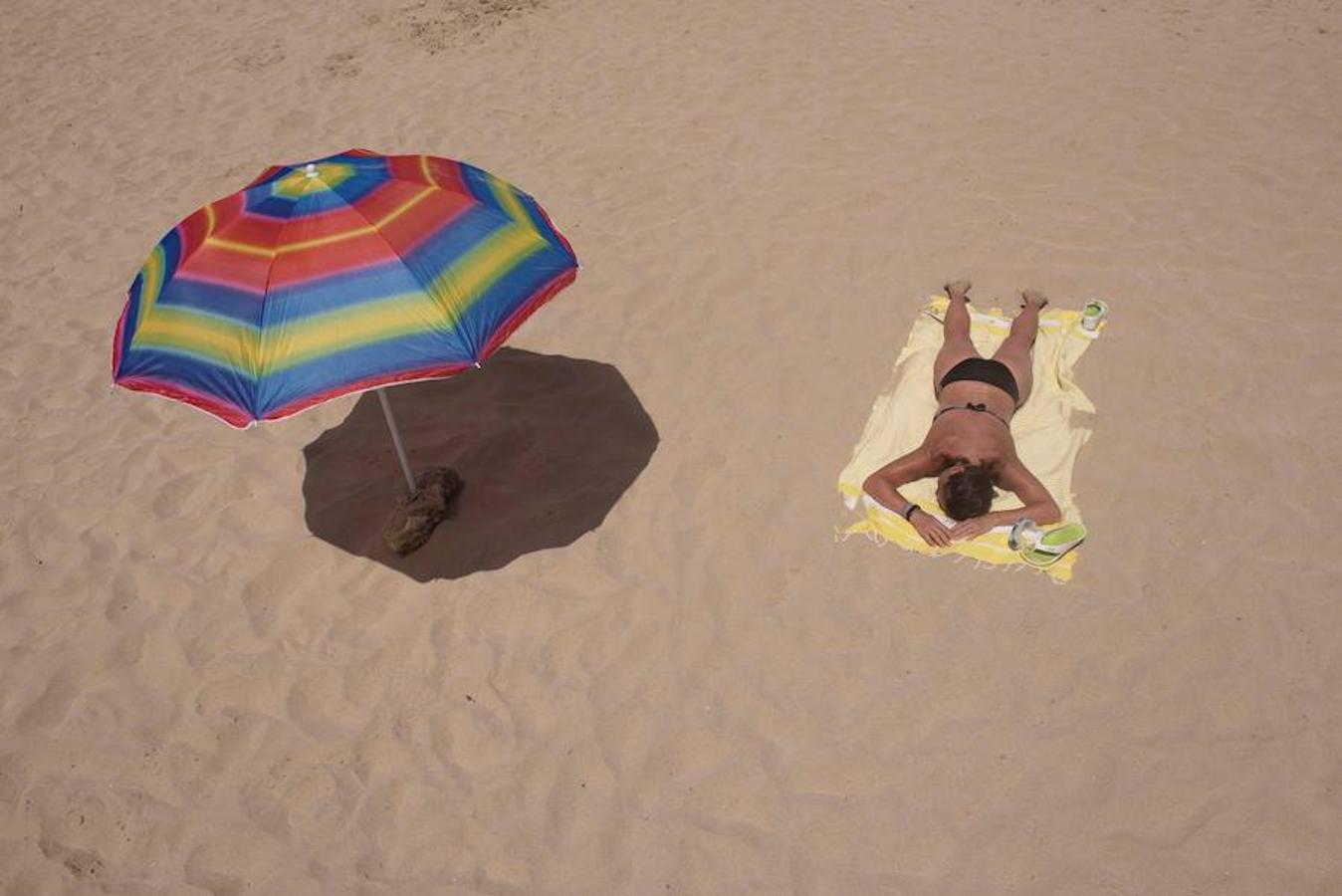 Una persona disfruta del sol en la playa de Arenal Díen Castell, en Menorca. 