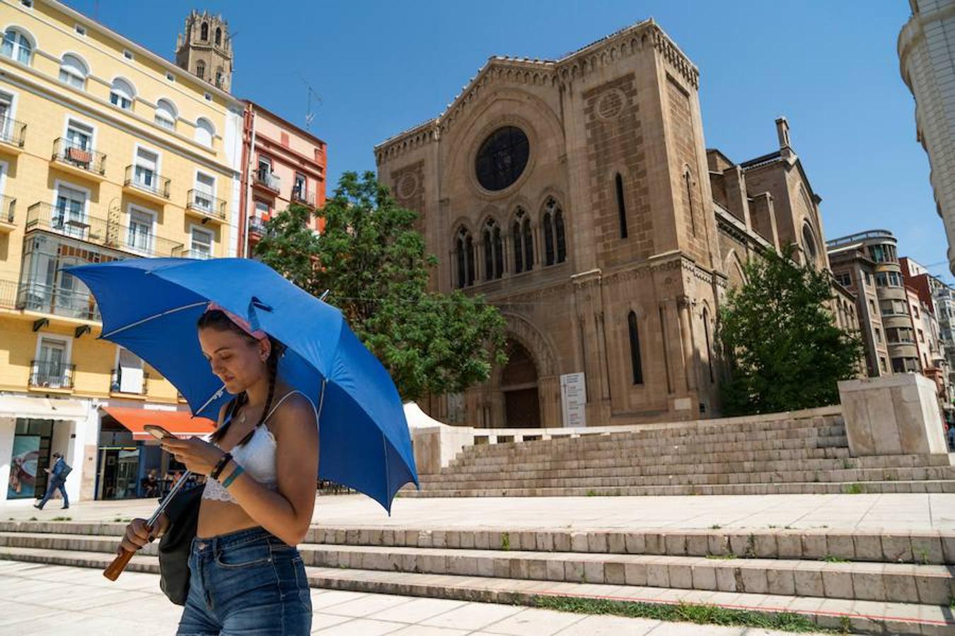 Una mujer se protege del sol con un paraguas en Lleida, lugar donde la ola de calor prevista para esta semana espera alcanzar niveles históricos de temperatura. 