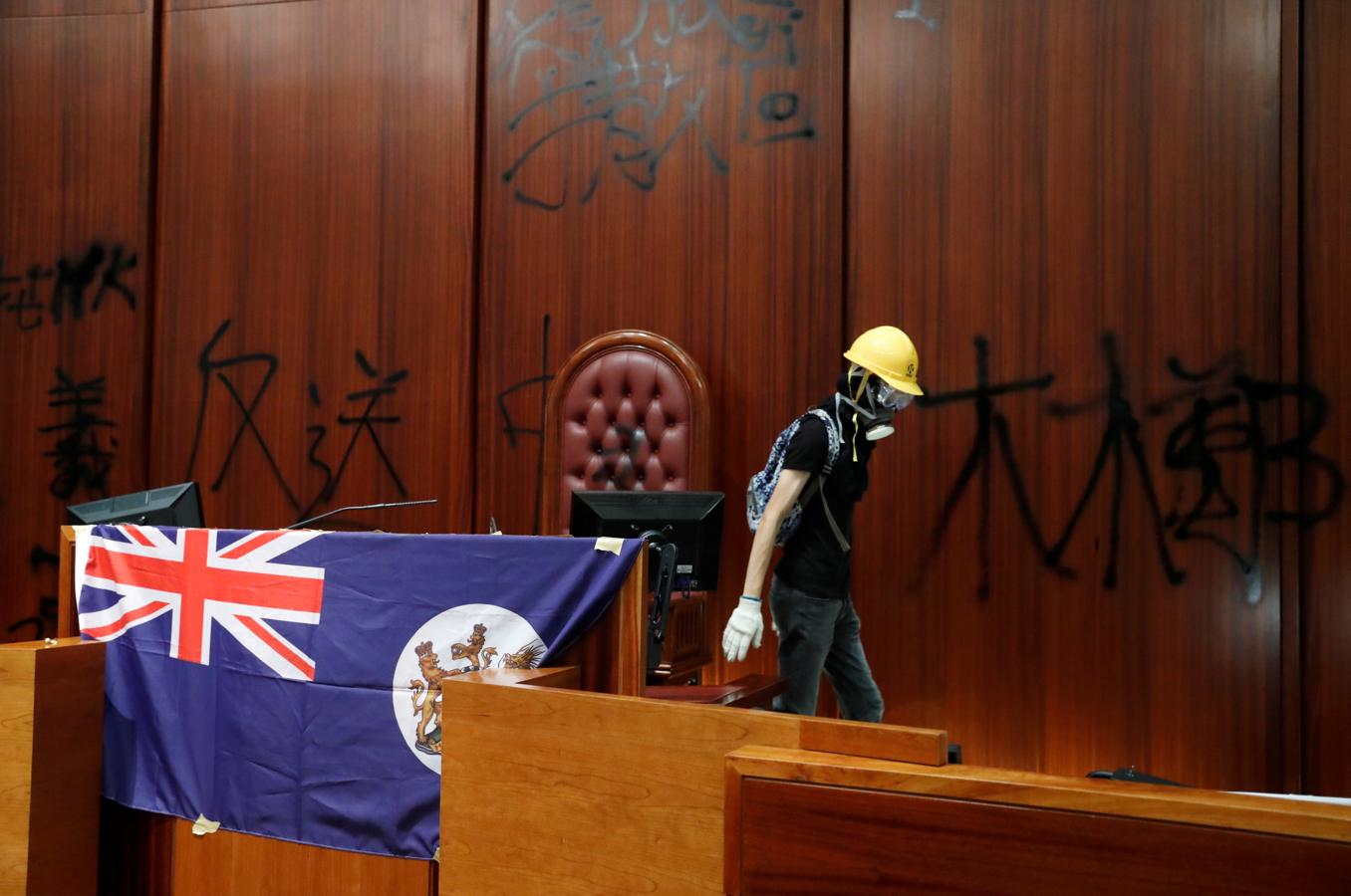 Un manifestante coloca la bandera de Reino Unido en el centro de la tribuna del Parlamento. 